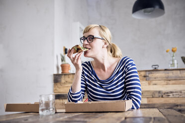 Porträt einer lächelnden Frau beim Pizzaessen - RBF05999