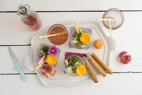 Salat zum Mitnehmen in Gläsern, Brotstangen und ein Glas Limonade auf dem Tablett, lizenzfreies Stockfoto