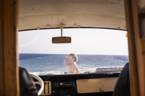 Spanien, Teneriffa, Frau steht am Meer hinter Lieferwagen, lizenzfreies Stockfoto