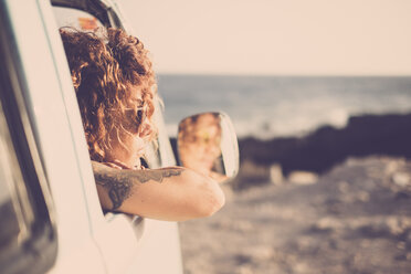 Tatooed woman looking out of a car - SIPF01728