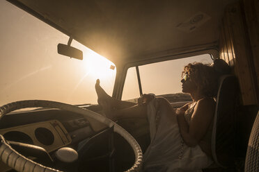 Spain, Tenerife, woman sitting in van at sunset - SIPF01737