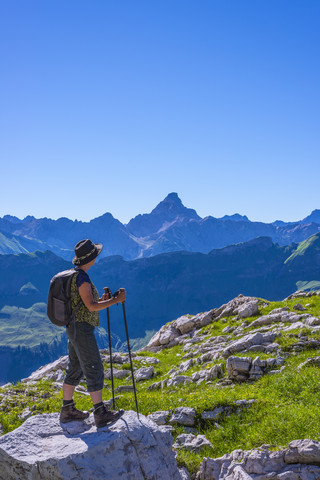 Deutschland, Bayern, Wanderer bei Koblat am Nebelhorn mit Hochvogel im Hintergrund, lizenzfreies Stockfoto