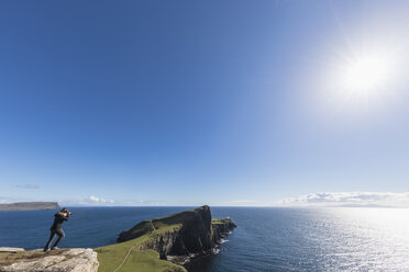 Vereinigtes Königreich, Schottland, Innere Hebriden, Isle of Skye, Tourist fotografiert den Leuchtturm am Neist Point - FOF09333