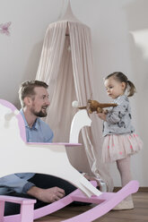 Vater spielt mit Kleinkind im Kinderzimmer seiner Tochter - SBOF00590