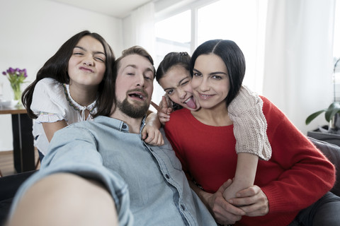 Parents and twin daughters fooling around taking a selfie stock photo