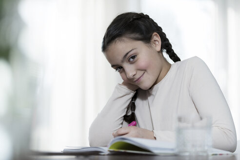 Porträt eines lächelnden Mädchens bei den Hausaufgaben - SBOF00646