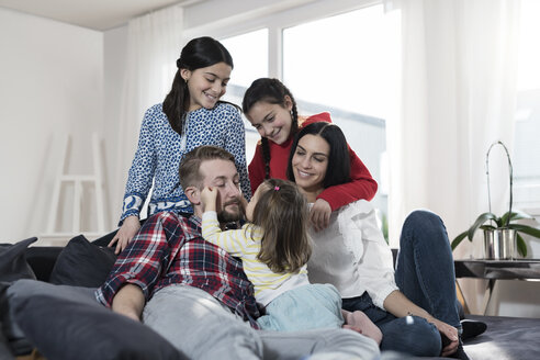 Eltern und drei Töchter auf dem Sofa im Wohnzimmer - SBOF00665