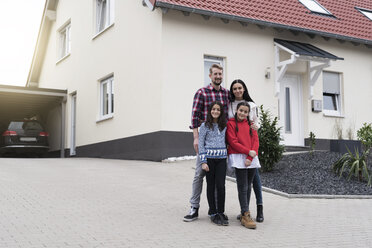 Portrait of parents and twin daughters in front of their family home - SBOF00666