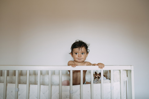 Portrait of baby girl in crib stock photo