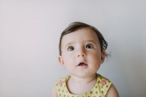 Überrascht Baby Mädchen schaut auf weißem Hintergrund, lizenzfreies Stockfoto