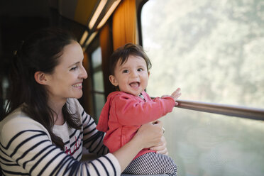 Happy mother and baby girl traveling by train - GEMF01802