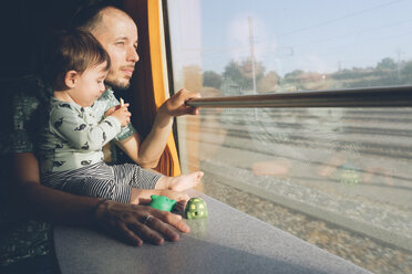 Vater und kleines Mädchen, die mit dem Zug reisen und aus dem Fenster schauen - GEMF01813