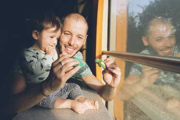 Father playing with his baby girl while traveling by train - GEMF01814