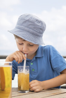 Junge bläst Seifenblasen mit Staw in seinem Softdrink - MIDF00852