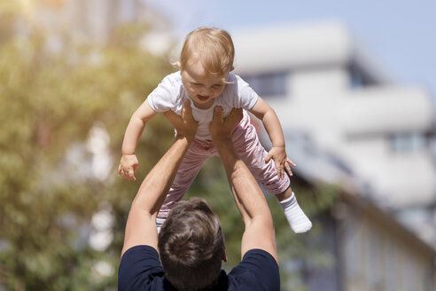 Vater hält kleine Tochter in die Höhe - MIDF00854