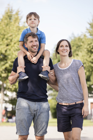 Glückliche Familie mit Vater, der seinen Sohn auf den Schultern trägt, lizenzfreies Stockfoto