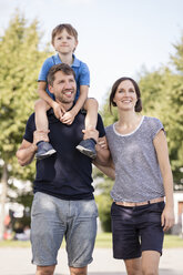 Happy family with father carrying son on shoulders - MIDF00861