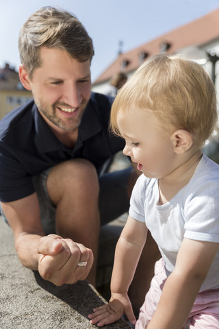 Father making a fist smiling at little daughter outdoors stock photo