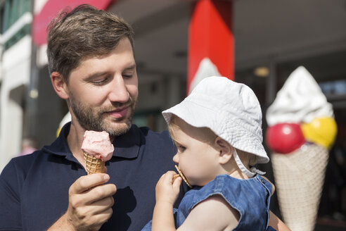 Vater isst Eis und hält seine Tochter - MIDF00876