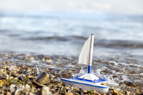 Toy boat at lakeshore stock photo