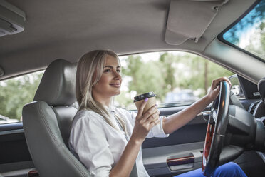 Lächelnde Geschäftsfrau mit Kaffee zum Mitnehmen am Steuer eines Autos - VPIF00049