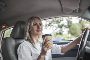 Lächelnde Geschäftsfrau mit Kaffee zum Mitnehmen am Steuer eines Autos - VPIF00050