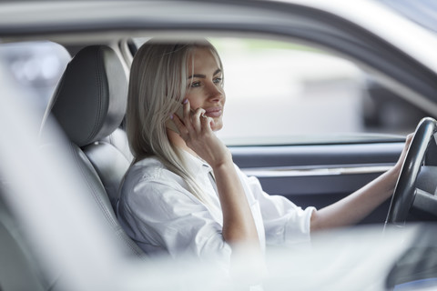 Geschäftsfrau am Handy beim Autofahren, lizenzfreies Stockfoto