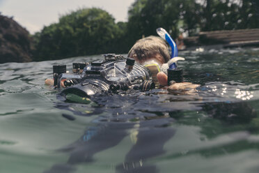 Mann mit Unterwassergehäuse einer DSLR-Kamera in einem See - MFF03925