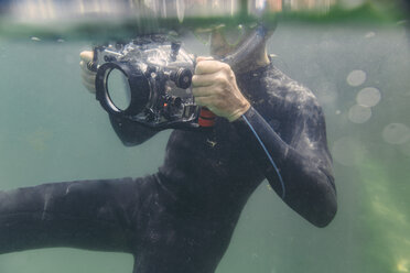 Mann taucht mit Unterwasser-DSLR-Kameragehäuse - MFF03927