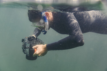 Mann taucht mit Unterwasser-DSLR-Kameragehäuse - MFF03931