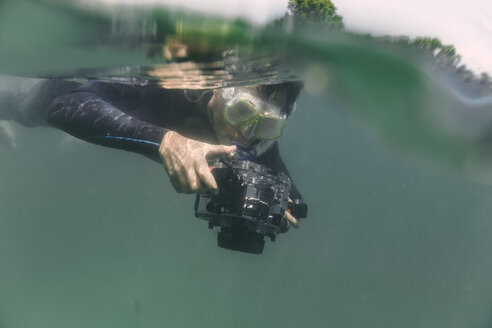 Mann taucht mit Unterwasser-DSLR-Kameragehäuse - MFF03932