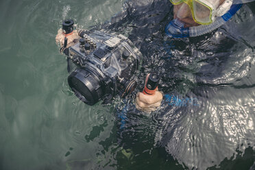 Mann mit Unterwassergehäuse einer DSLR-Kamera in einem See - MFF03933