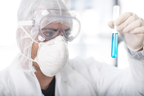 Wissenschaftler arbeitet im Labor und hält ein Reagenzglas, lizenzfreies Stockfoto