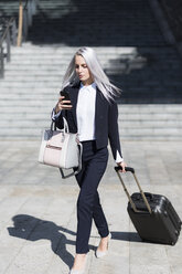 Young businesswoman on the go in the city checking cell phone - GIOF03199