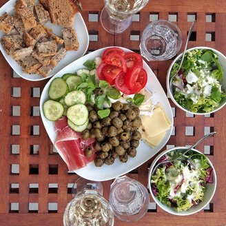 abendessen mit Oliven, Gurken, Tomaten, Käse, Salat, Brot, Wasser und Wein, Berlin, Deutschland - NGF00398