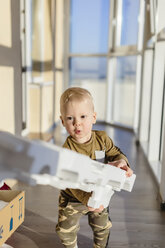 Kleinkind beim Auspacken eines Kartons - KNTF00879