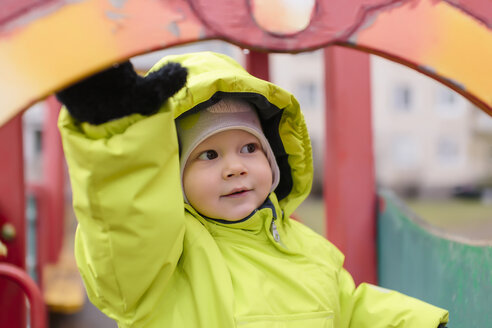 Kleinkind mit Regenjacke auf dem Spielplatz - KNTF00883