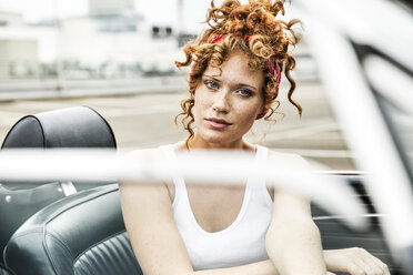 Portrait of redheaded woman in sports car - FMKF04504