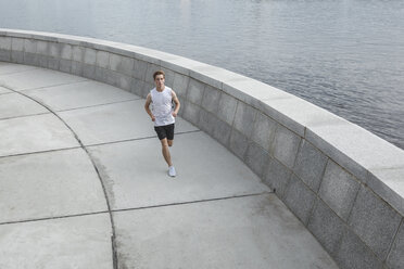 Junger Mann läuft am Flussufer - VPIF00070