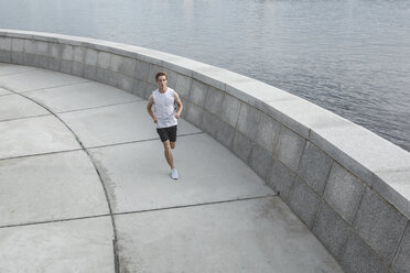 Young man running at the riverbank - VPIF00070