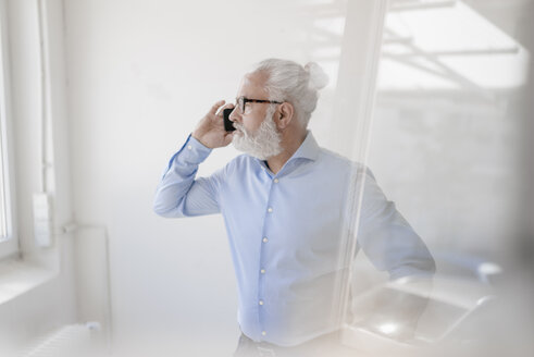 Älterer Mann mit Bart und Brille am Mobiltelefon - JOSF01700