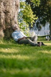 Mature man with laptop relaxing in park - JOSF01743