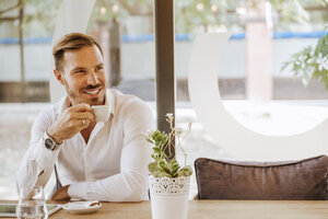 Lächelnder Mann mit Tablet trinkt Espresso in einem Café - ZEDF00847