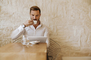 Mann mit Tablet trinkt Espresso in einem Cafe - ZEDF00848