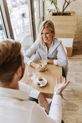 Happy young woman looking at man in a cafe - ZEDF00853