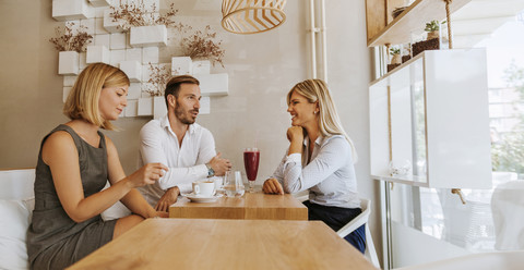 Drei Freunde treffen sich in einem Cafe, lizenzfreies Stockfoto