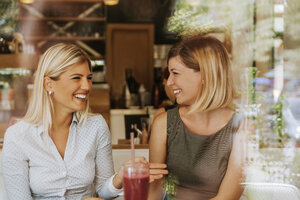 Zwei glückliche junge Frauen in einem Cafe - ZEDF00860