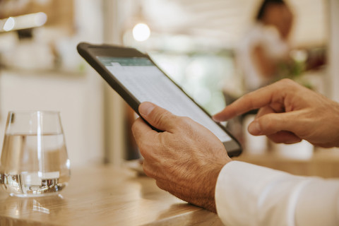 Close-up of man using tablet in a cafe stock photo