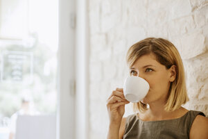 Junge Frau trinkt eine Tasse Kaffee - ZEDF00874