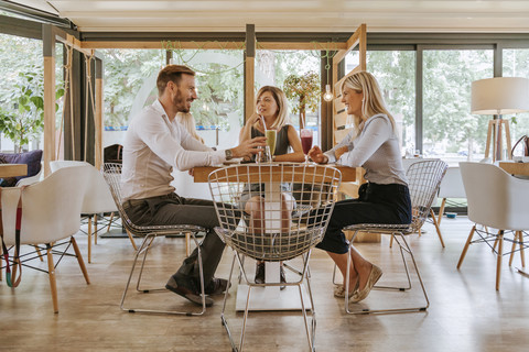 Drei Freunde treffen sich in einem Cafe, lizenzfreies Stockfoto